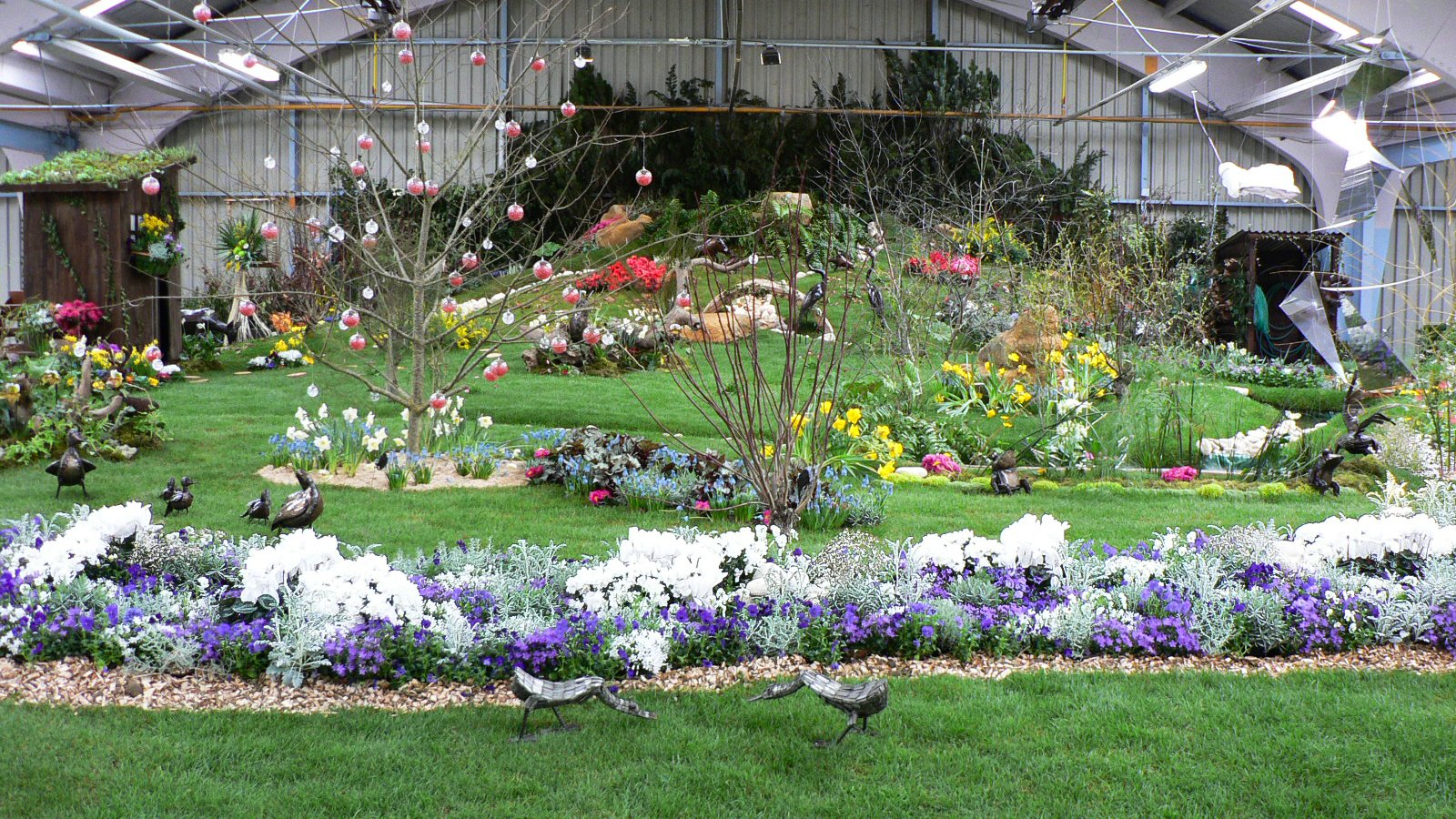 massif fleuri en pente fleurs blanches et bleues au 1° plan